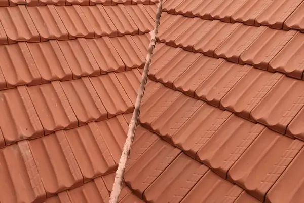Restored concrete tile roof valley with re-bedded tiles and a fresh coating