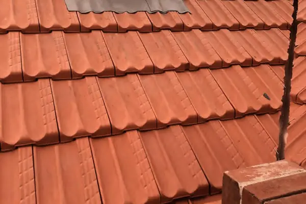 Tiled roof with new flashing and repointed brickwork around a chimney