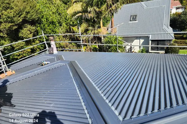 New grey long-run Colorsteel roof with hips and ridges finished, on an Auckland home