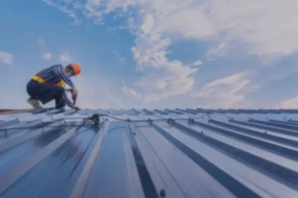 Roofer fixing new long-run steel sheets on a residential re-roof