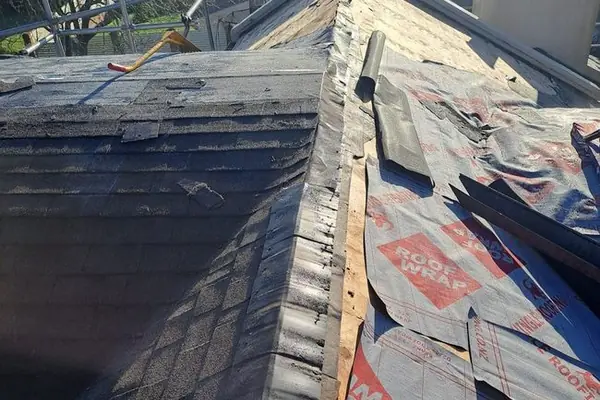 Shingle roof opened to the underlay for repairs along the ridge